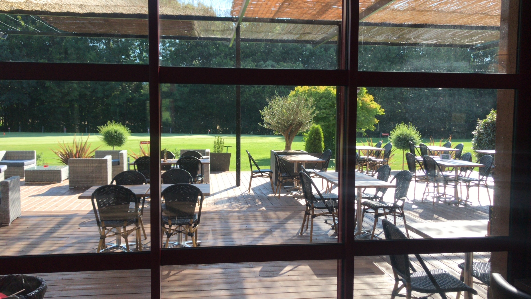 Vue depuis l'intérieur du restaurant sur la terrasse et le parcours
