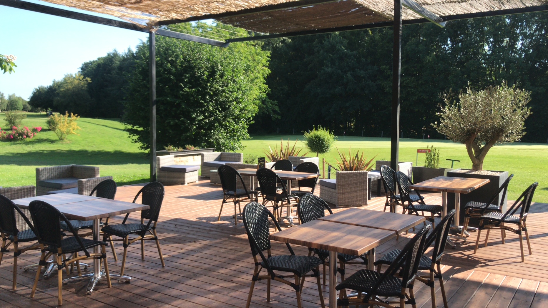 La terrasse sous pergola avec vue sur le parcours et le jardin